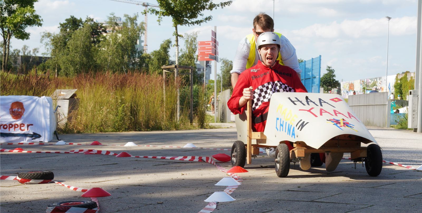 Eine Gruppe versucht gemeinsam eine Seifenkiste zu montieren